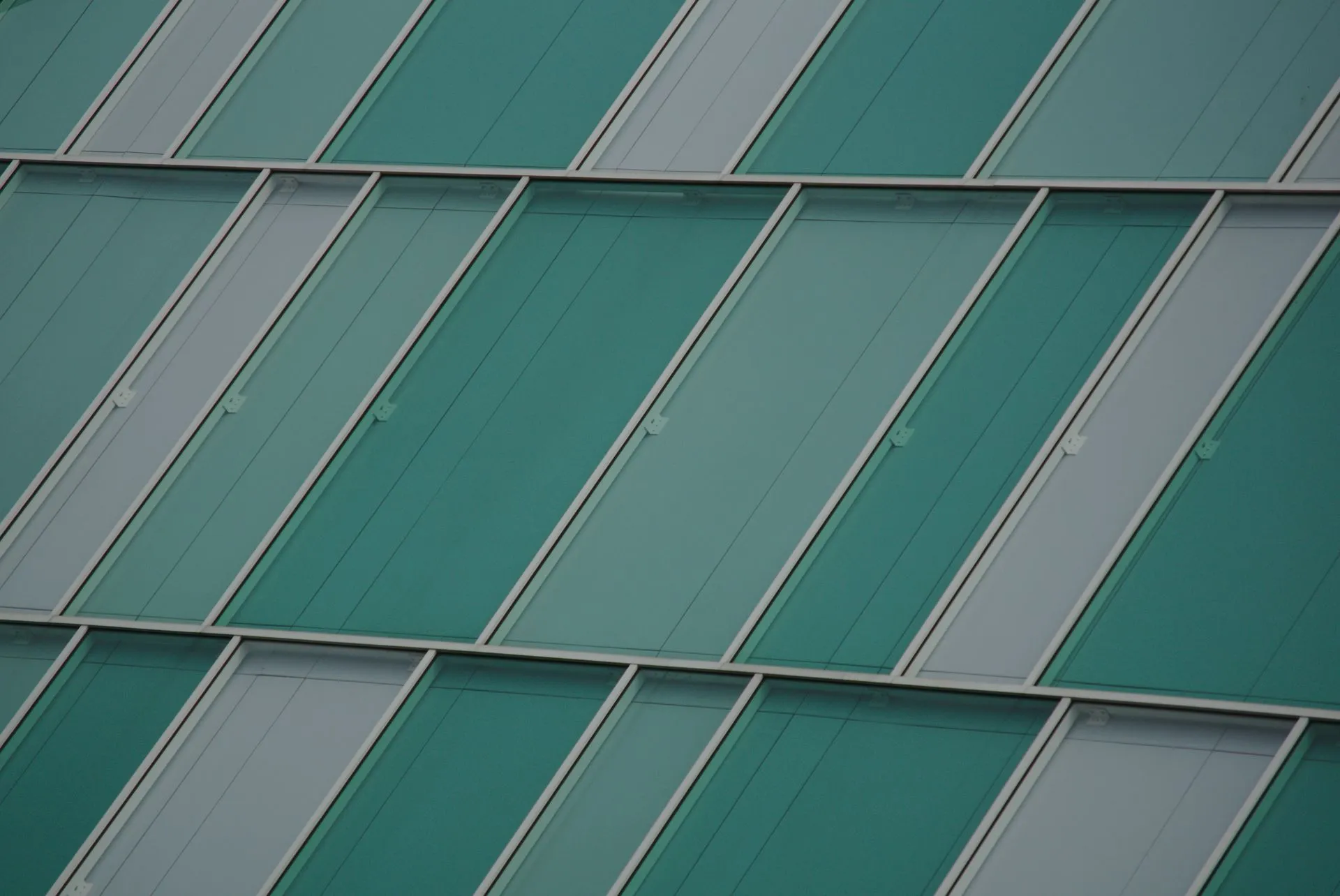 Detail of a modern glass facade in teal tones